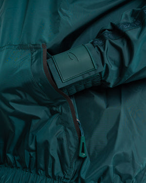 Man in a green sauna suit tracksuit with a white boxraw logo on the chest as well as adjustable wrist straps and made from polyester.