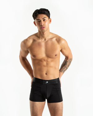 Man in black nylon slim fit boxers with white strike logo on waistband