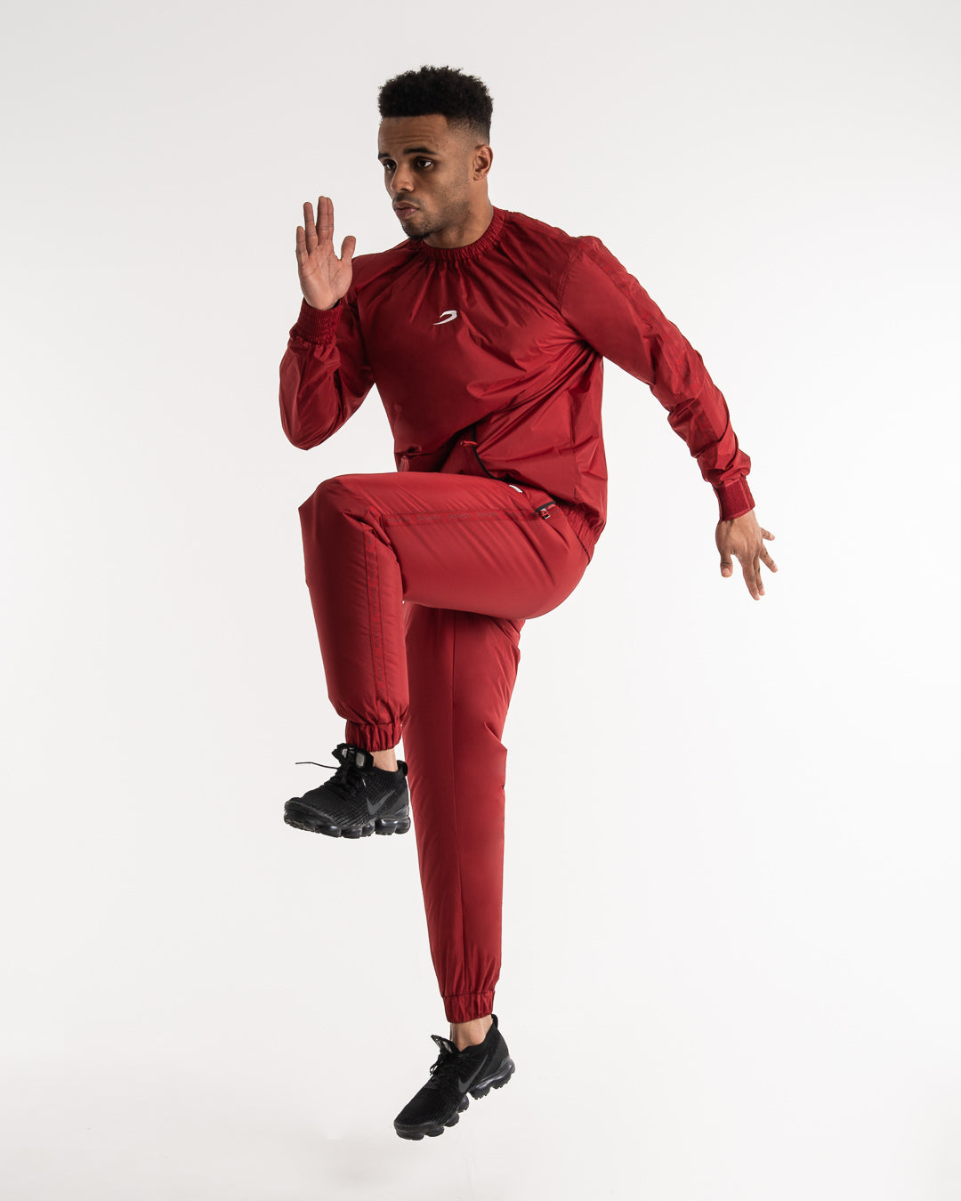 Man in a red sauna suit tracksuit with a white boxraw logo on the chest as well as adjustable wrist straps and made from polyester.