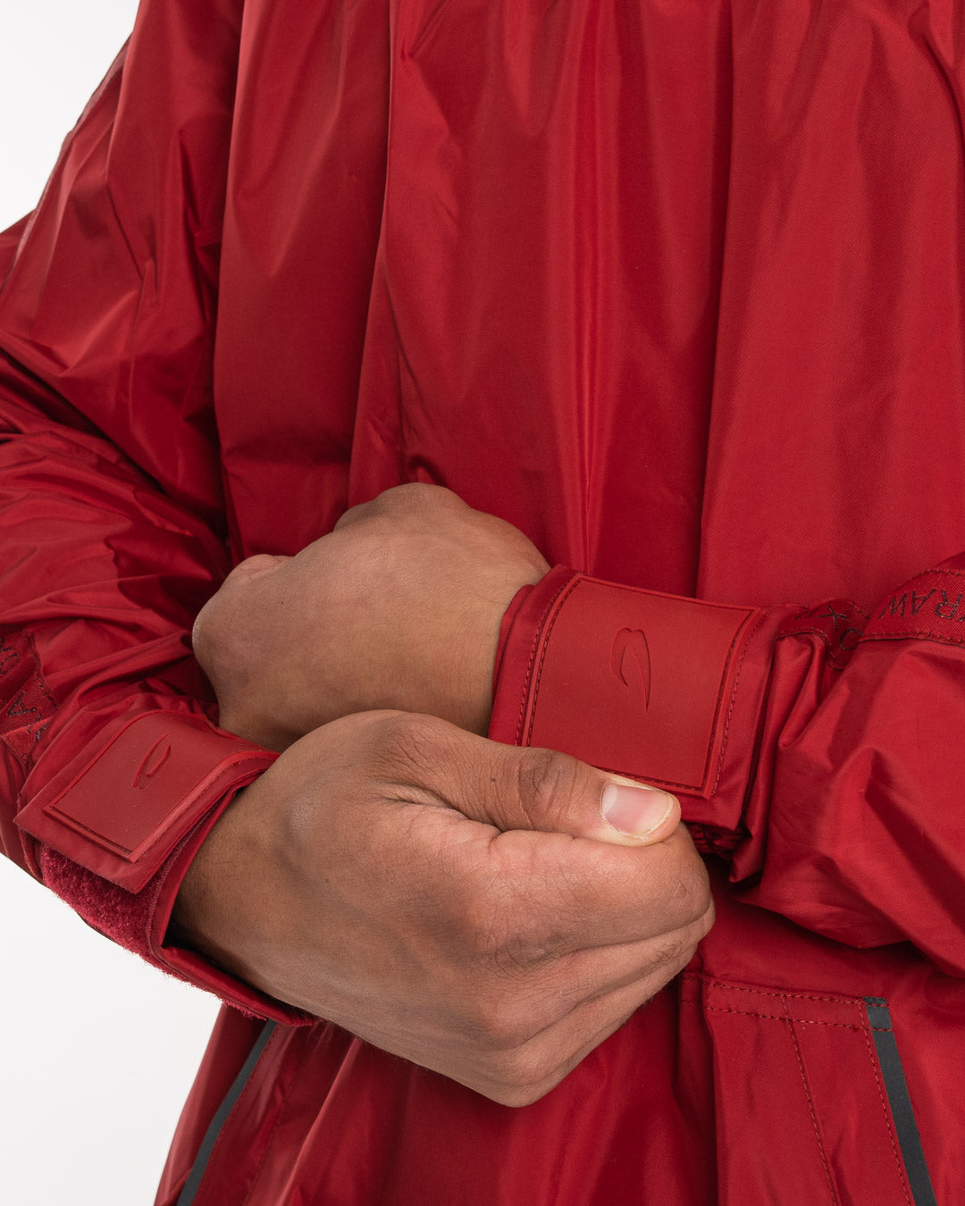 Man in a red sauna suit tracksuit with a white boxraw logo on the chest as well as adjustable wrist straps and made from polyester.