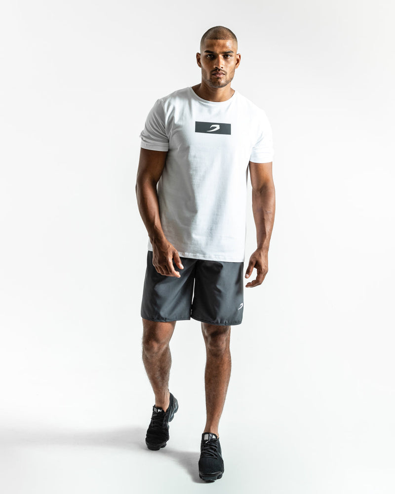 Man in charcoal training shorts with adjustable waistband and side zipped pockets as well as an embroidered white boxraw strike logo.