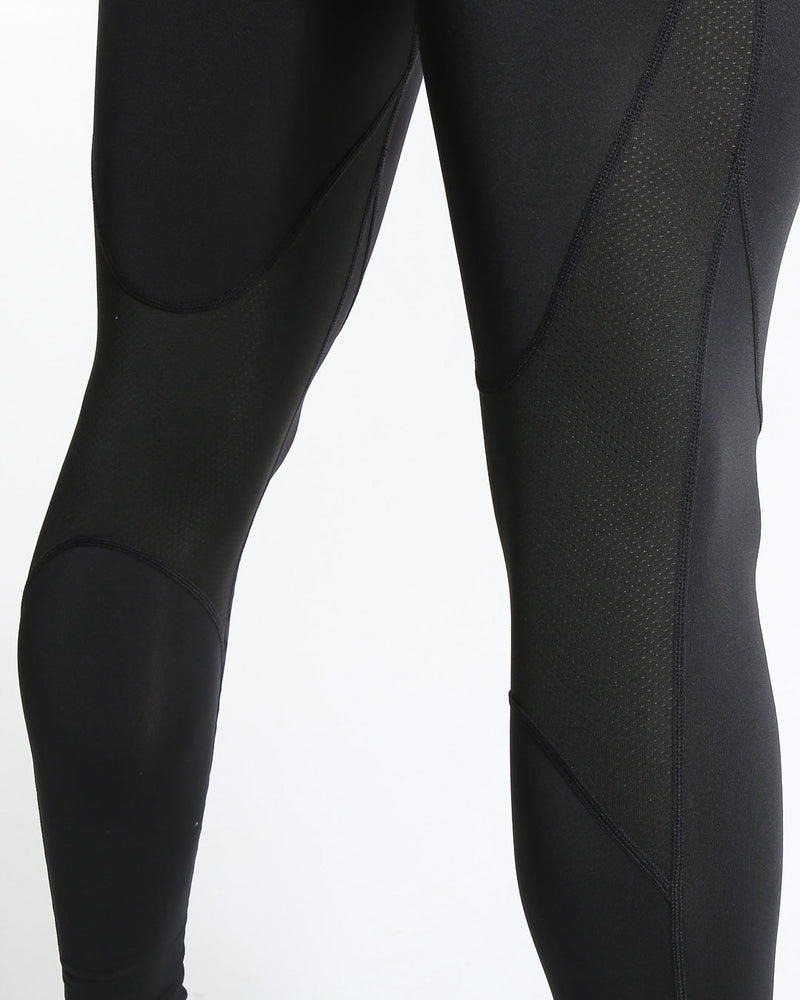 Man in black compression leggings/tights with wide elastic waistband and a white 3D strike logo on the leg.